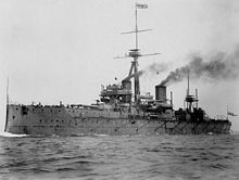 Ship at sea with smoke emitting from two funnels