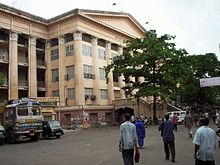 A big building in cream colour with many columns and a portico