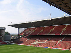 A grandstand at a sports stadium.  The seats are predominantly red.